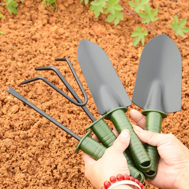 Ein Vierteiliges Gartengeräte-set – Bestehend Aus Einer Schaufel Zum Pflanzen Von Blumen Und Gemüse, Einer Gartenkelle Zum Jäten Und Einem Gartenrechen.